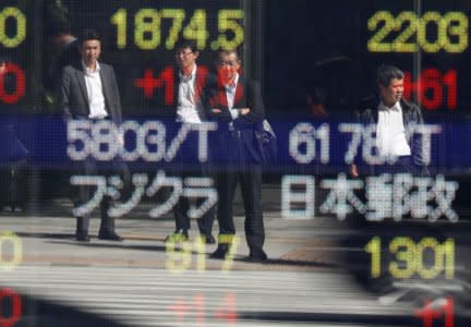 Passersby are reflected in an electronic stock quotation board outside a brokerage in Tokyo, Japan, October 23, 2017.   REUTERS/Issei Kato