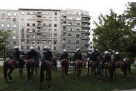 Police on their horses guard the area as people gather for a demonstration in Belgrade, Serbia, Wednesday, July 8, 2020. Serbia's president Aleksandar Vucic backtracked Wednesday on his plans to reinstate a coronavirus lockdown in Belgrade after thousands protested the move and violently clashed with the police in the capital. (AP Photo/Darko Vojinovic)