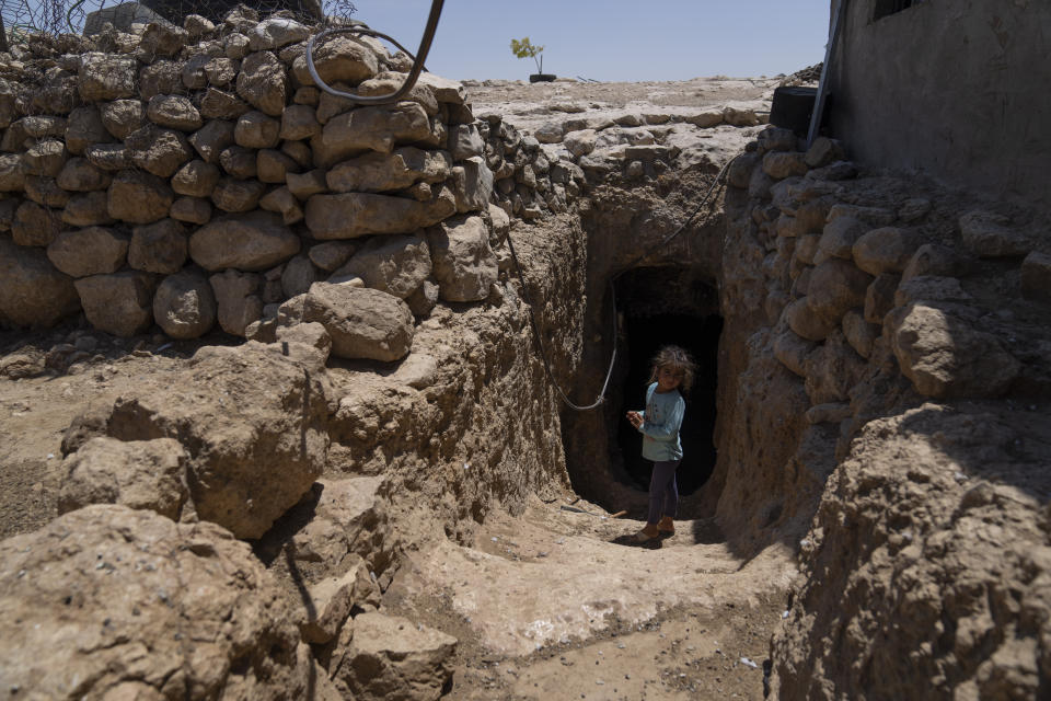 Zeynab Abu Sabaha, 3 stands at the entrance of her family's cave at the Palestinian hamlet of al-Fakheet, in the cluster of Bedouin communities in Masafer Yatta, West Bank, Monday, Aug. 1, 2022. Palestinians living in Masafer Yatta, in the occupied West Bank, fear they could be expelled at any time after Israel's Supreme Court ruled in favor of the military earlier this year in a two-decade legal battle. (AP Photo/Nasser Nasser)