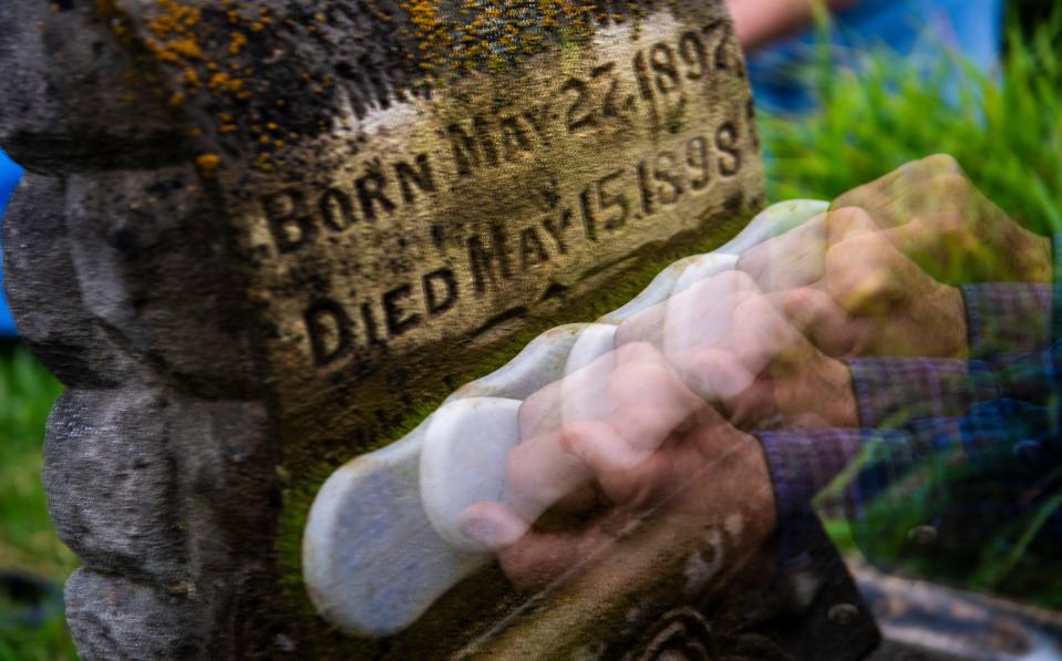 Patrick Murray scrubs a gravestone during the headstone restoration workshop at Rose Hill Cemetery put on by Monroe County History Center Cemetery Committee and the Prospect Hill Neighborhood Association on Saturday, June 29, 2024.