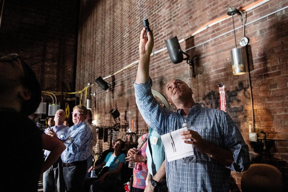 Chris Corl, director of Community and Regional Entertainment Facilities, points to an area where bricks fell onto the stage in February in the Thomas Wolfe Auditorium during a tour August 21, 2023.