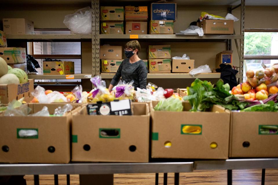 A volunteer helps organize food products at Manna for Life Ministries in Green Bay.