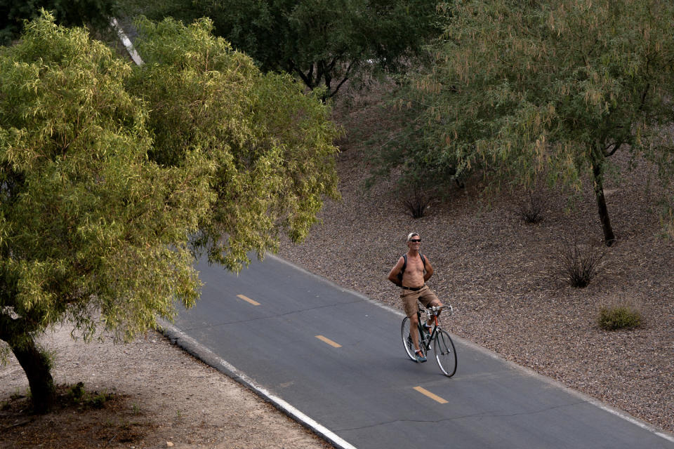 Image: A man rides his bike during a brutal heat wave in Tucson, Ariz., on July 15. (Rebecca Noble / AFP via Getty Images file)