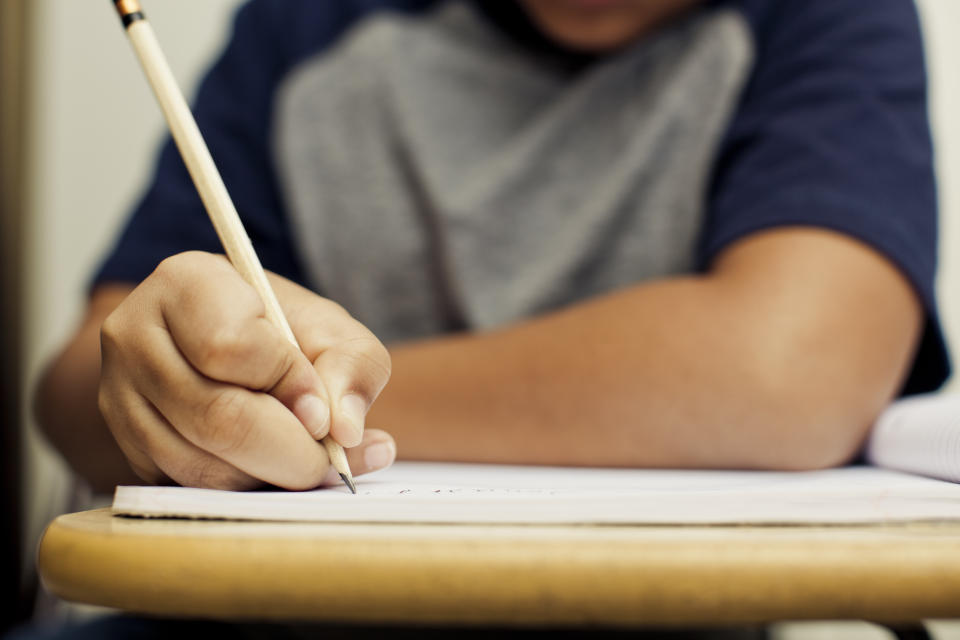 a young boy takes a test with a pencil