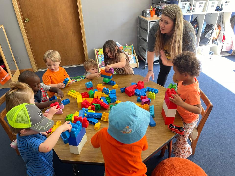 PiggyToes owner/operator Trish Watts encourages children to play with blocks at the day care's new location in Grovetown, April 22, 2022.