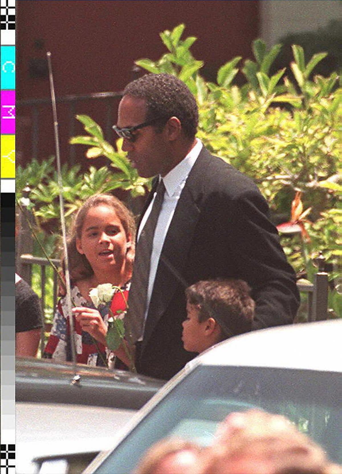 OJ Simpson-  ex-football superstar O.J. Simpson accompanying his children, Sydney, 9 (L) and Justin, 6 (R), as they leave the funeral services for his ex-wife, Nicole Simpson, 16 June 1994 (AFP via Getty Images)