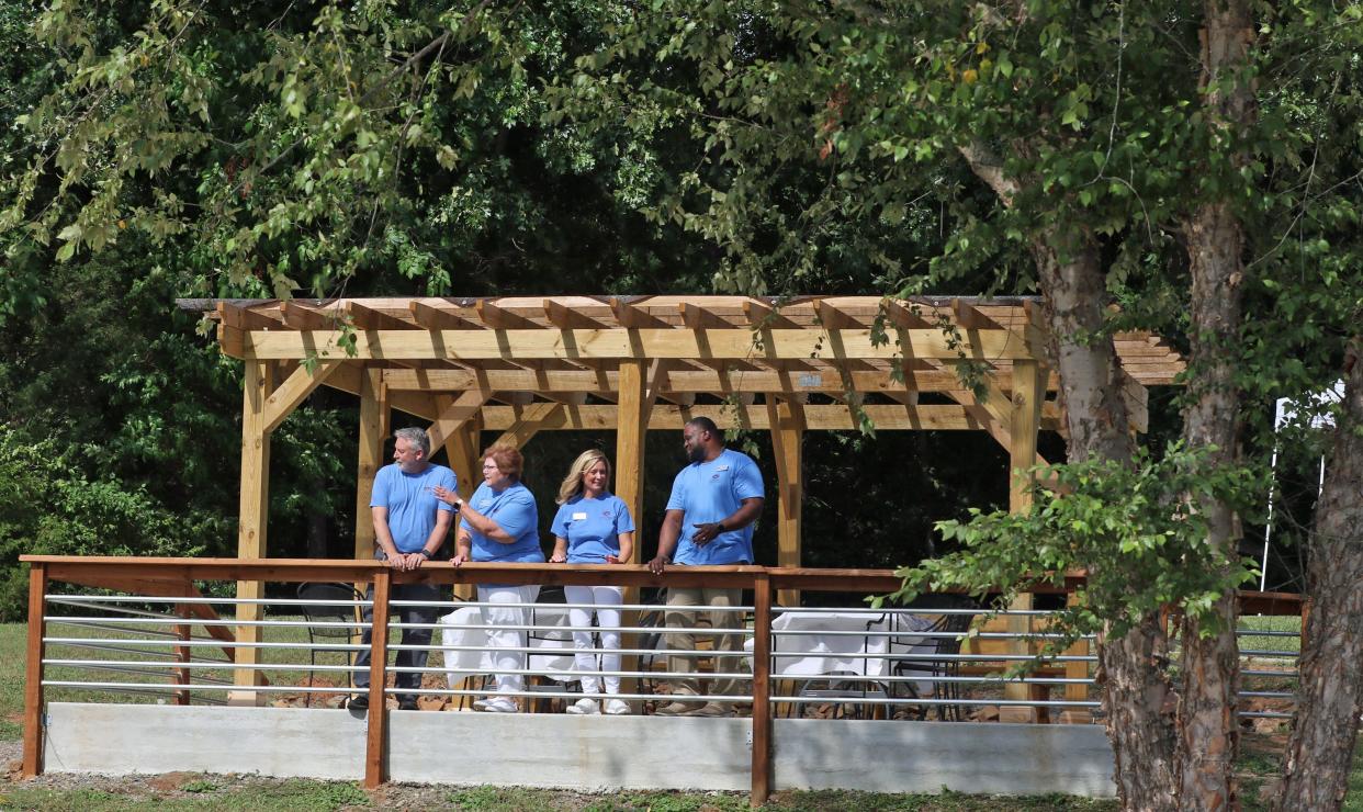 Jay Hinds, Regina Moody, Kerri Massey and Donnie Thurman check out the view of the lake from the new outdoor sitting area during the Grand Reopening of Camp Hope Tuesday afternoon, July 12, 2022, on River Run near Belmont.