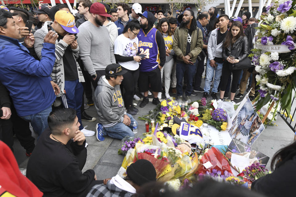 People gather at a memorial near Staples Center after the death of Laker legend Kobe Bryant Sunday, Jan. 26, 2020, in Los Angeles. (AP Photo/Michael Owen Baker)