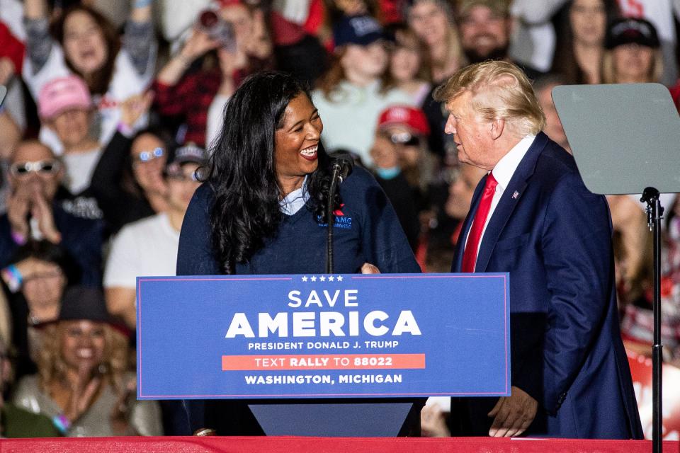 Kristina Karamo, Republican candidate for Michigan Secretary of State shakes hands with former President Donald Trump during a Save America rally at the Michigan Stars Sports Center in Washington Township on April 2, 2022.