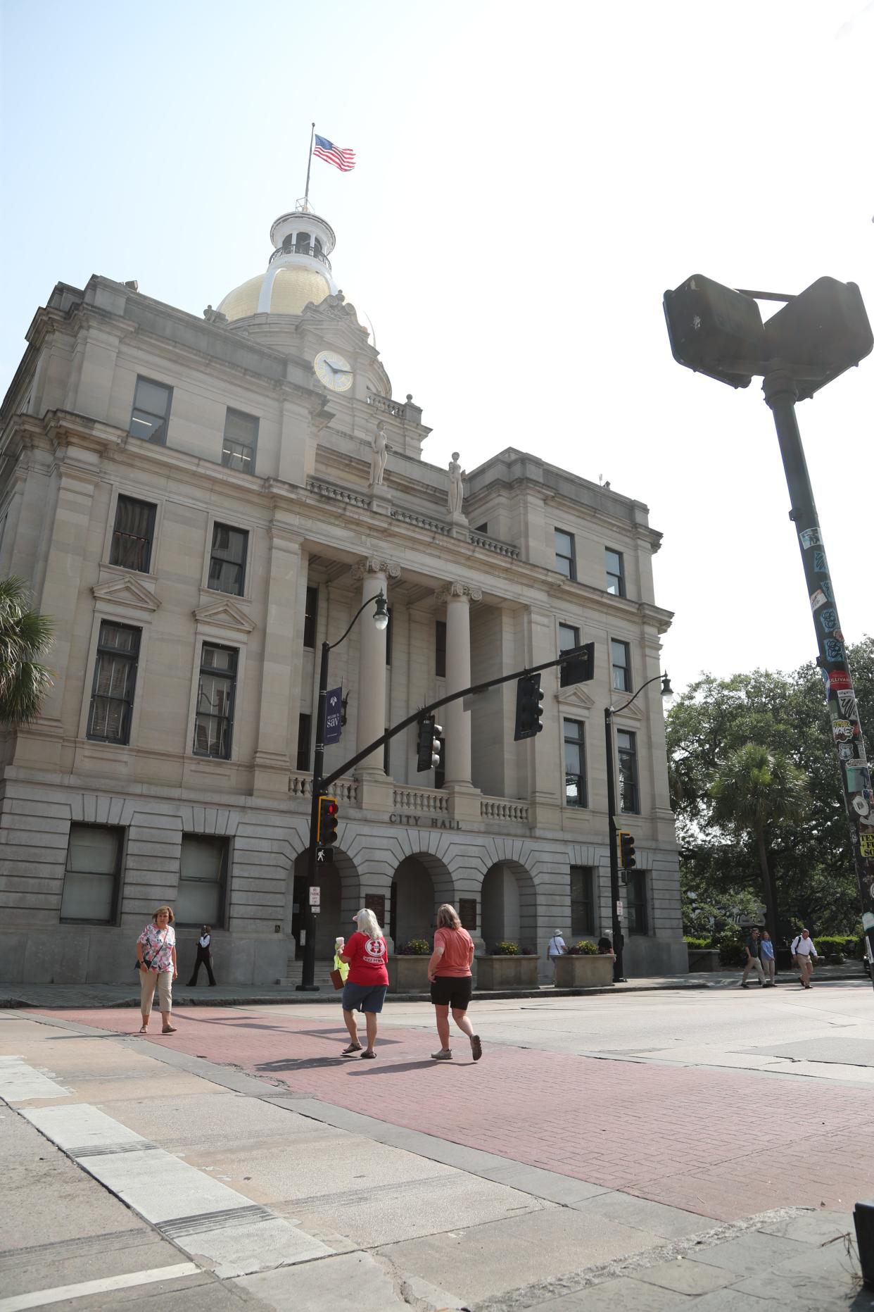 Pedestrians cross Bay Street near Savannah City Hall.
