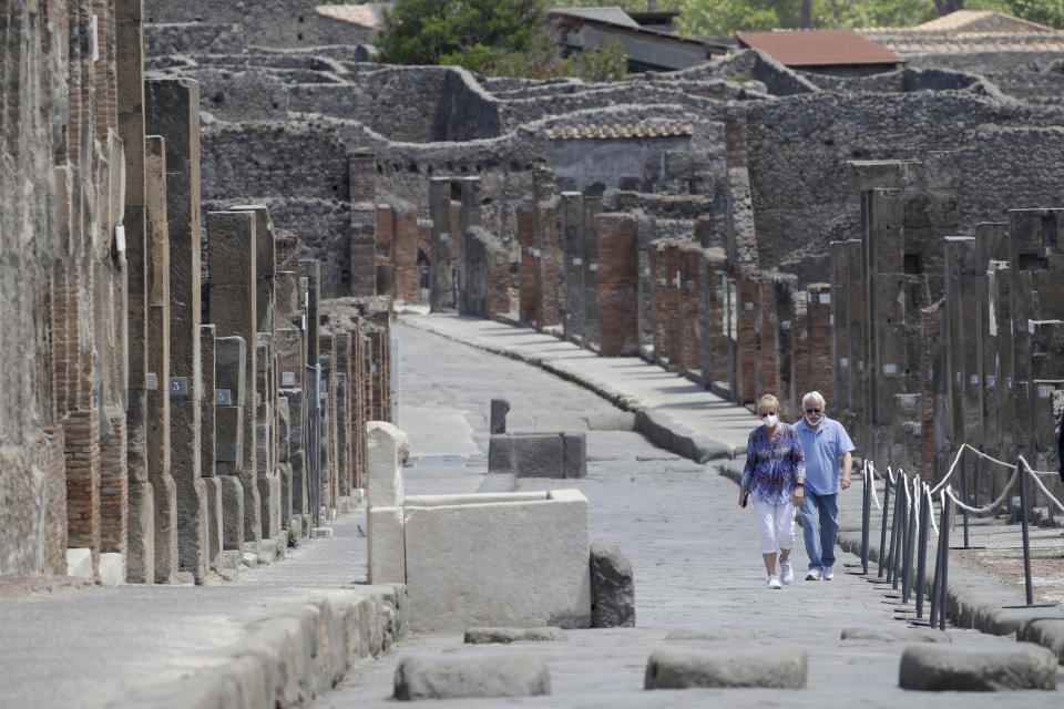 Colleen and Marvin Hewson, from the United States, visit the archaeological site of Pompeii, near Naples, southern Italy, Tuesday, May 26, 2020. The American couple waited a lifetime plus 2 ½ months to visit the ancient ruins of Pompeii together. For Colleen and Marvin Hewson, the visit to the ruins of an ancient city destroyed in A.D. 79 by a volcanic eruption was meant to be the highlight a trip to celebrate his 75th birthday and their 30th anniversary. They were among the only tourists present when the archaeological site reopened to the public on Tuesday after the national lockdown to prevent the spread of COVID-19. (AP Photo/Alessandra Tarantino)