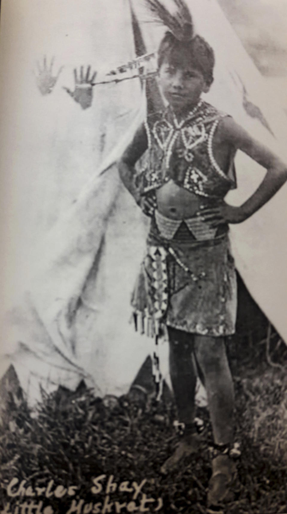 In this undated image provided by the Charles Shay Family Archive, Charles Norman Shay poses in native dress as a young boy in Indian Island, Maine. Shay, a D-Day veteran, was a medic who on June 6, 1944, landed on Omaha Beach, where he helped drag wounded soldiers out of the rising tide. (Charles Shay Family Archive via AP)