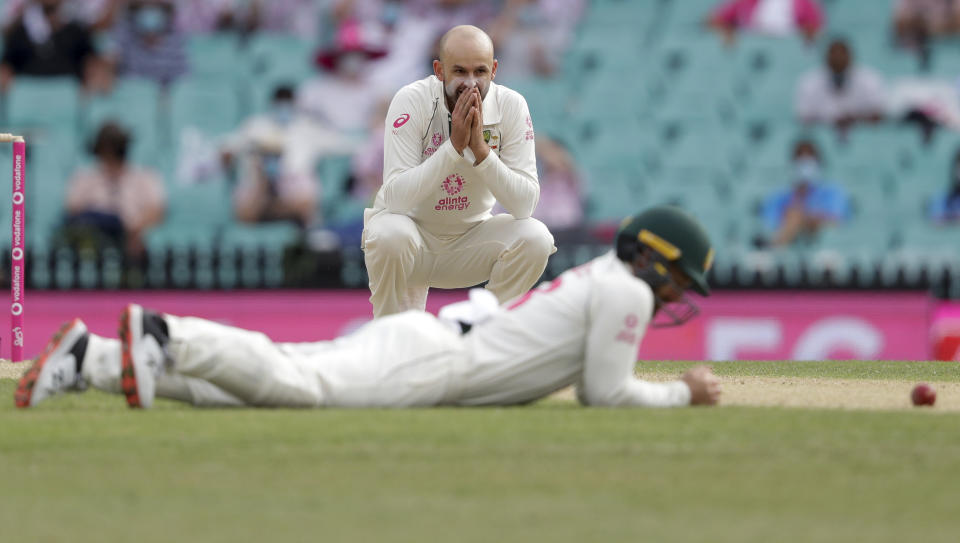 Australia's Nathan Lyon reacts as teammate Australia's Matthew Wade missed a catch opportunity during play on day two of the third cricket test between India and Australia at the Sydney Cricket Ground, Sydney, Australia, Friday, Jan. 8, 2021. (AP Photo/Rick Rycroft)