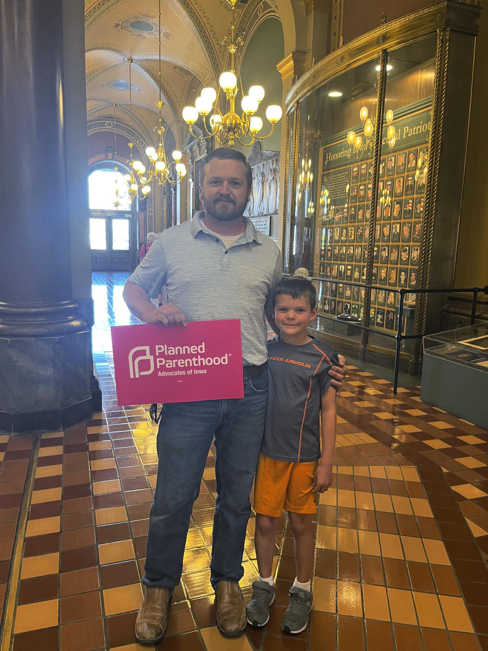 Tim Rutledge, 37, and his son, 8, join protesters at the Iowa Capitol rotunda to voice opposition to the new ban on abortion after roughly six weeks of pregnancy introduced by Republican lawmakers in a special session in Des Moines, Iowa, on Tuesday, July 11, 2023. (AP Photo/Hannah Fingerhut)