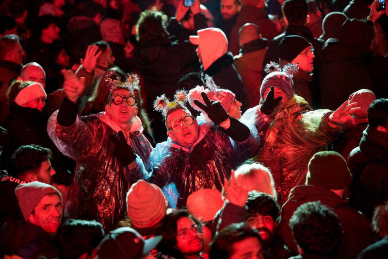Visitors celebrate during the New Year's Eve at the Brandenburg Gate party. Sebastian Christoph Gollnow/dpa