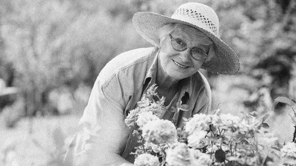 elderly woman in the garden tending to her flowers