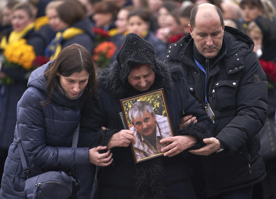 In this photo provided by the Ukrainian Presidential Press Office, relatives of one of the flight crew members of the Ukrainian 737-800 plane that crashed on the outskirts of Tehran, arrive for memorial service at Borispil International Airport outside Kyiv, Ukraine, Sunday, Jan. 19, 2020. A Ukrainian passenger jet carrying 176 people crashed just minutes after taking off from the Iranian capital's main airport on Jan. 8, 2020, killing all aboard. (Ukrainian Presidential Press Office via AP)