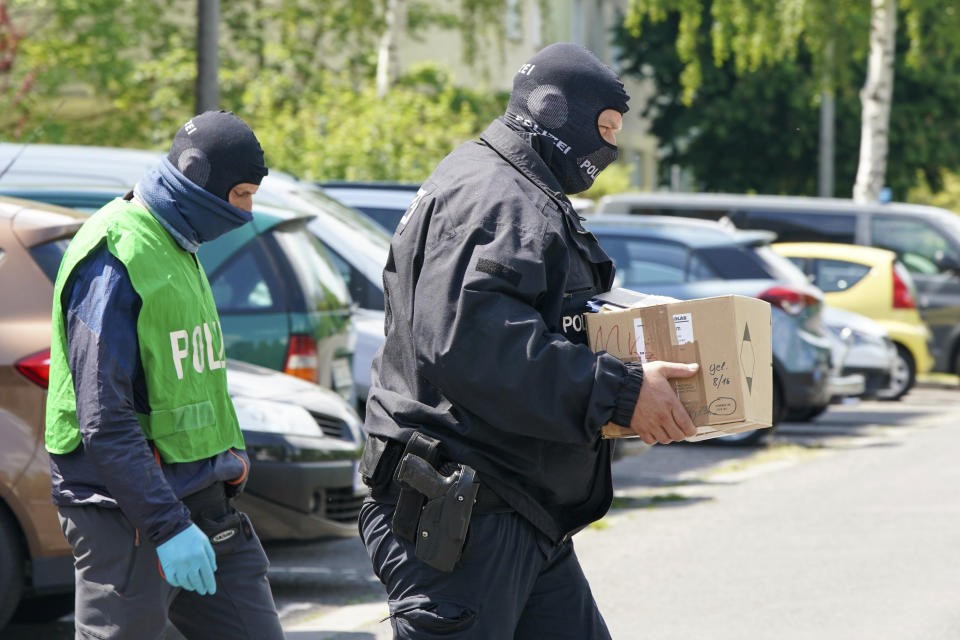 Federal police officers carry a box with secured documents during raids in Leipzig, Germany, Wednesday, May 27, 2020. Police in Germany have raided dozens of homes linked to anti-government groups suspected of manufacturing fake documents. (Peter Endig/dpa via AP)