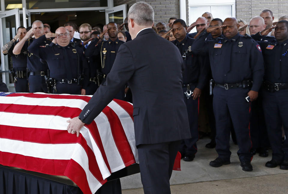 Brookhaven police officers salute as the flag draped coffin of Brookhaven, Miss., police officer James White, rolled towards the waiting hearse following his funeral service, Wednesday, Oct. 3, 2018, at Easthaven Baptist Church in Brookhaven. White and Corporal Zach Moak were killed early Saturday, Sept. 30, responding to a call. (AP Photo/Rogelio V. Solis)