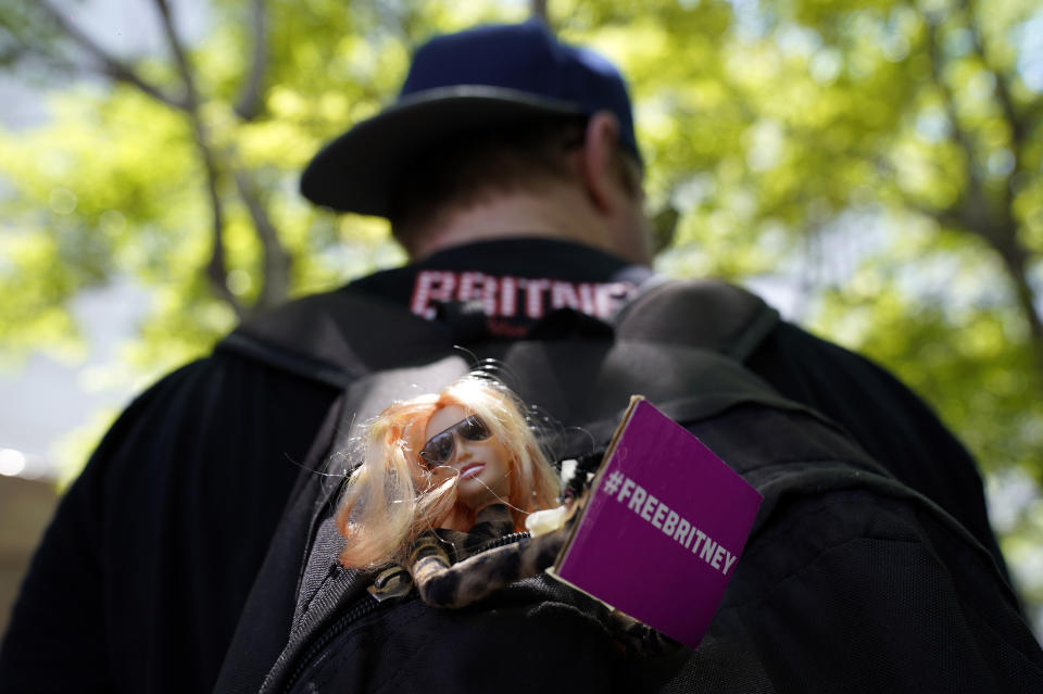 Saige Douglas of Denver carries a Britney Spears doll in his backpack outside a court hearing concerning the pop singer's conservatorship at the Stanley Mosk Courthouse, Wednesday, June 23, 2021, in Los Angeles. (AP Photo/Chris Pizzello)