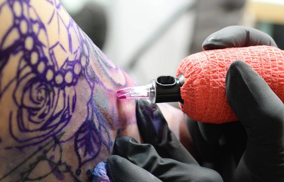 Stacy Smith works on a tattoo for customer Bridgette Byerly.