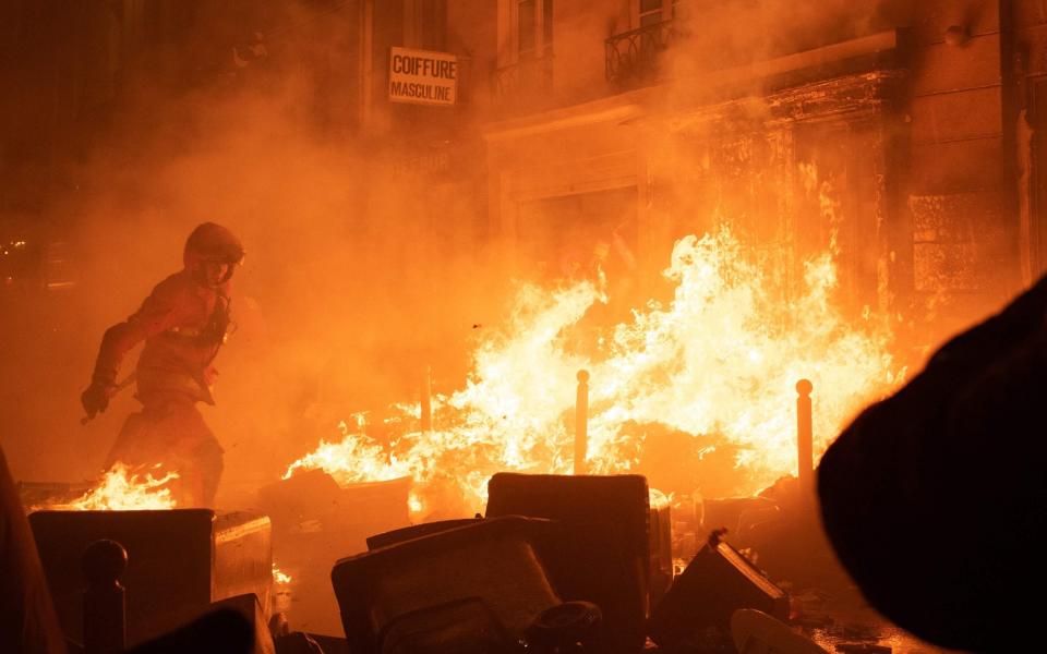 A firefighter tries to extinguish a fire - ANNA KURTH/AFP via Getty Images