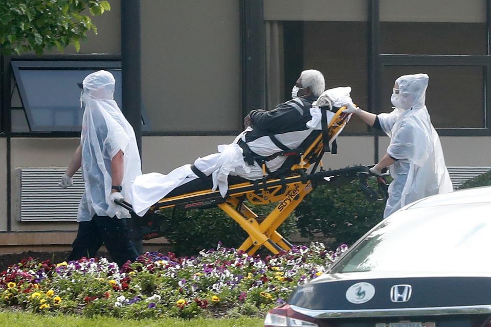 A nursing home resident is wheeled on a stretcher from an ambulance into the Canterbury Rehabilitation and Healthcare Center on April 14, 2020. At the time, the nursing home was one of the worst clusters of fatalities from COVID-19 in the country, with 42 deaths.