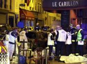 A general view of the scene shows rescue service personnel working near the covered bodies outside a restaurant following a shooting incident in Paris, France, November 13, 2015. REUTERS/Philippe Wojazer