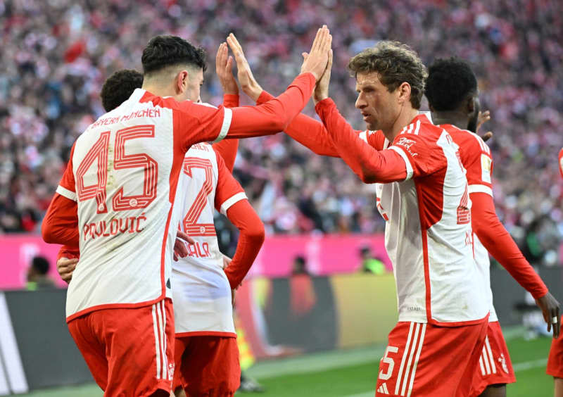 Munich's Aleksandar Pavlovic (L) and Thomas Mueller celebrate their first goal during the German Bundesliga soccer match between Bayern Munich and Borussia Moenchengladbach at the Allianz Arena. Angelika Warmuth/dpa