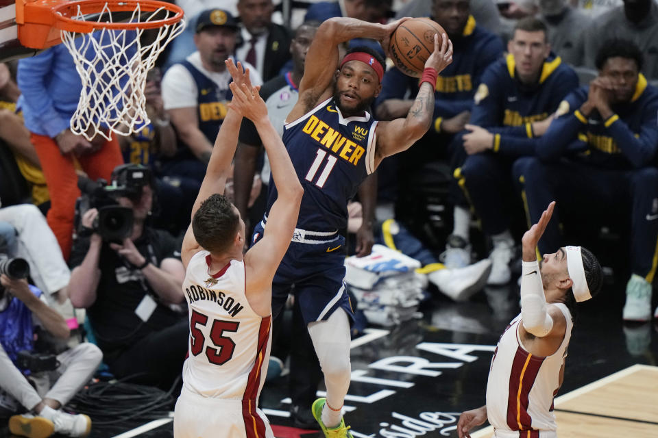 Denver Nuggets forward Bruce Brown (11) looks to pass the ball under pressure from Miami Heat forward Duncan Robinson (55) 130during the first half of Game 4 of the basketball NBA Finals, Friday, June 9, 2023, in Miami. (AP Photo/Lynne Sladky)