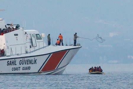 A line is thrown from a Turkish Coast Guard ship off the shores of Bodrum, Turkey, as migrants in a dinghy paddle on the Mediterranean Sea in a failed attempt of crossing to the Greek island of Kos, September 19, 2015. REUTERS/Umit Bektas