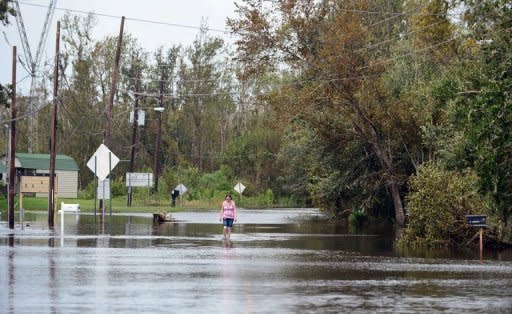 A woman makes her way out of her flooded neighborhood outside New Orleans, on August 31. White House challenger Mitt Romney has toured storm-ravaged New Orleans in a bid to burnish his presidential credentials ahead of his November battle with Barack Obama