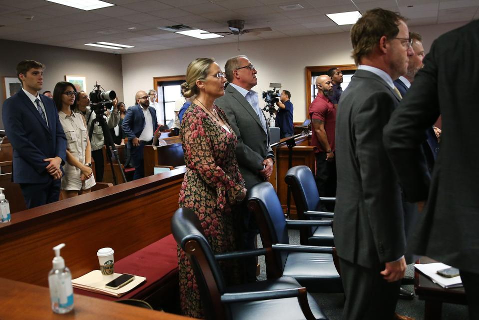 Scarlett Lewis, left, and Neil Heslin, right, the parents of 6-year-old Sandy Hook Elementary shooting victim Jesse Lewis, rise as state District Judge Maya Guerra Gamble enters the courtroom Thursday at the Travis County Courthouse. The parents are seeking $150 million in damages from Austin-based conspiracy theorist Alex Jones after he was found to have defamed the parents for calling the Newtown, Conn., attack a hoax.