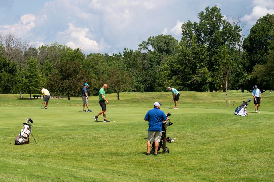 Los golfistas practican el putting durante la clasificación para el torneo de golf masculino de la ciudad en el campo de golf Fendrich el sábado 22 de julio de 2023.