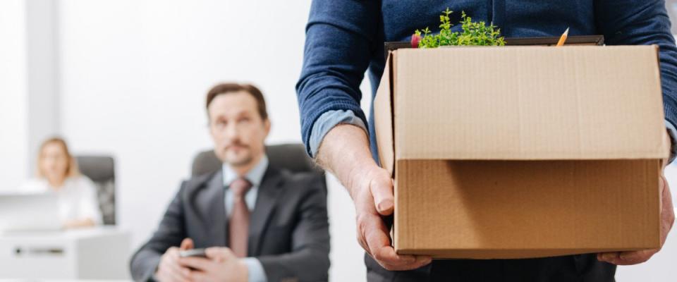 Confident employee leaving the office with his personal stuff