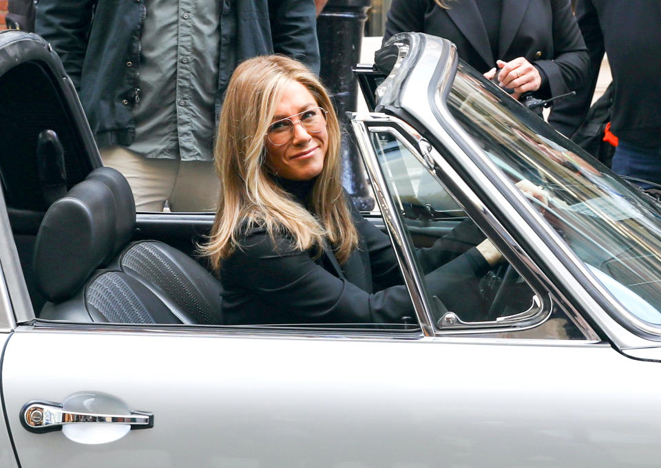 <p>Jennifer Aniston gives the cameras a grin on the New York City set of <em>The Morning Show</em> on Sept. 26. </p>
