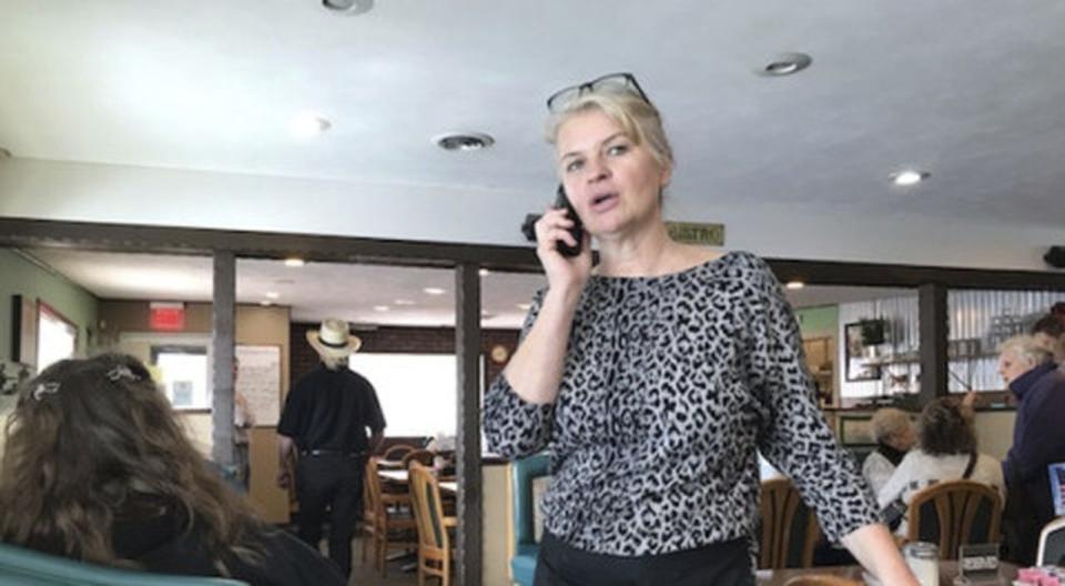 Marlena Pavlos-Hackney talks on a cell phone at her Holland restaurant, Marlena's Bistro & Pizzeria, on Thursday, March 18, 2021, in Holland, Mich. Michigan State Police arrested Pavlos-Hackney on Friday, March 19, 2021. State investigators say she ignored caps on restaurant capacity and wasn't enforcing mask rules. Her food license was suspended Jan. 20, but the eatery remained open. (John Agar/The Grand Rapids Press via AP)