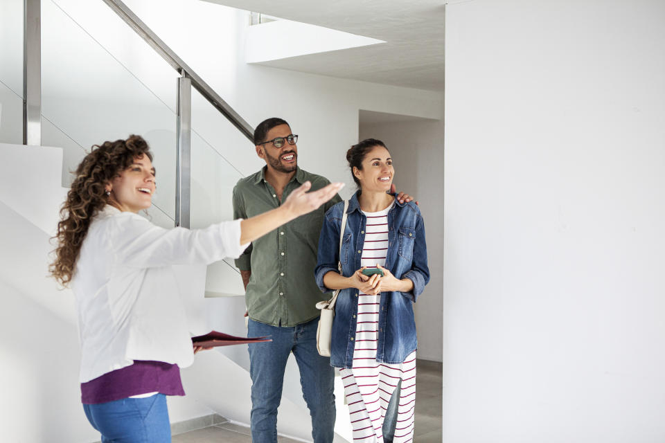 A realtor showing a house to a couple.