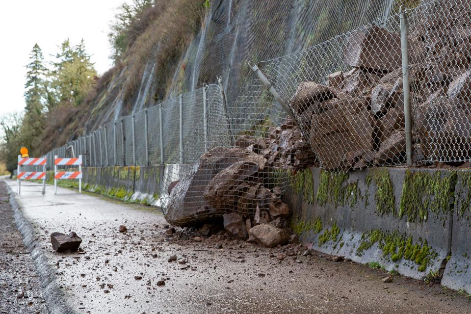 Rocks broke a fence during a landslide on River Road South.