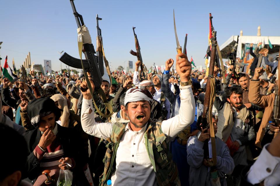 Houthi fighters brandish their weapons during a protest in the capital Sanaa on Jan. 12, 2024.