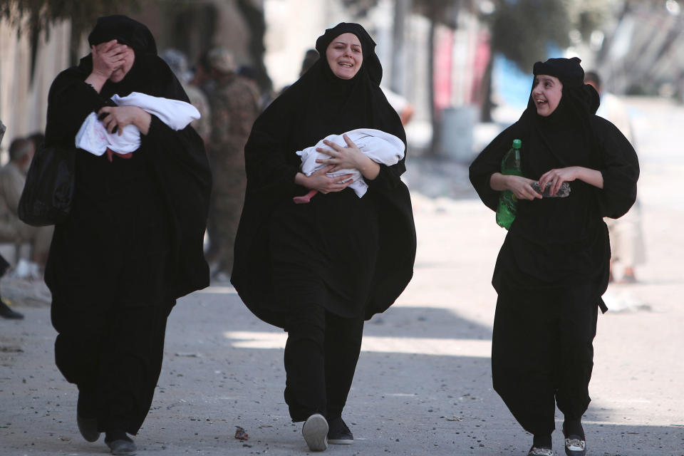 <p>Women carry newborn babies while reacting after they were evacuated by the Syria Democratic Forces (SDF) fighters from an Islamic State-controlled neighbourhood of Manbij, in Aleppo Governorate, Syria, Aug. 12, 2016. (REUTERS/Rodi Said) </p>