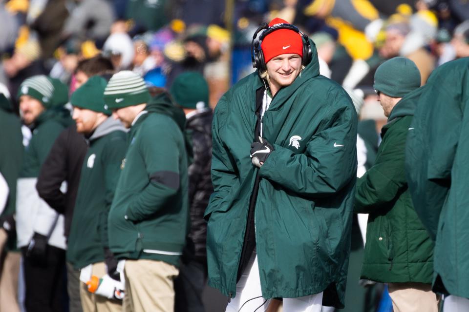 Michigan State Spartans quarterback Rocky Lombardi stays warm on the sideline during the game at Michigan Stadium on Saturday, Nov. 16, 2019.