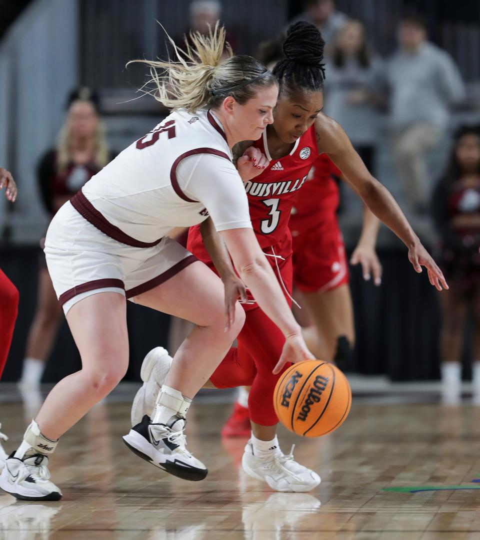 Bellarmine's Claire Knies (15) tried to maintain control while being defended by U of L's Chrislyn Carr (3) during their game at Freedom Hall in Louisville, Ky. on Dec. 14, 2022.