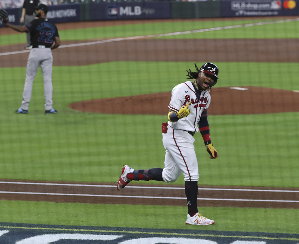 El venezolano Ronald Acuña festeja tras conectar un jonrón solitario ante el dominicano Sandy Alcántara (izquierda), de los Marlins de Miami, en el primer juego de la serie divisional de la Liga Nacional, el martes 6 de octubre de 2020, en Houston (Curtis Compton/Atlanta Journal-Constitution via AP)