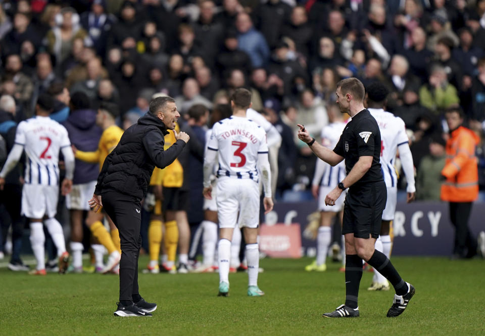 Wolverhampton Wanderers manager Gary O'Neil, left, speaks with referee Thomas Bramall as fans invade the pitch, during the English FA Cup fourth round soccer match between West Bromwich Albion and Wolverhampton Wanderers, at The Hawthorns, in West Bromwich, England, Sunday, Jan. 28, 2024. (Bradley Collyer/PA via AP)