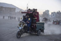 Spectators leave on a three wheel vehicle after watch wrestling matches in Kabul, Afghanistan, Friday, Nov. 19 , 2021. The scene is one played out each week after Friday prayers in the sprawling Chaman-e-Huzori park in downtown Kabul, where men, mainly from Afghanistan's northern provinces, gather to watch and to compete in pahlawani, a traditional form of wrestling. (AP Photo/ Petros Giannakouris)