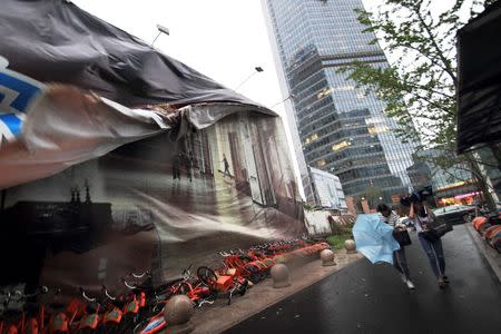 People walk against wind brought by Typhoon Megi in Shaoxing, Zhejiang province, China, September 28, 2016. Picture taken September 28, 2016. China Daily/via REUTERS