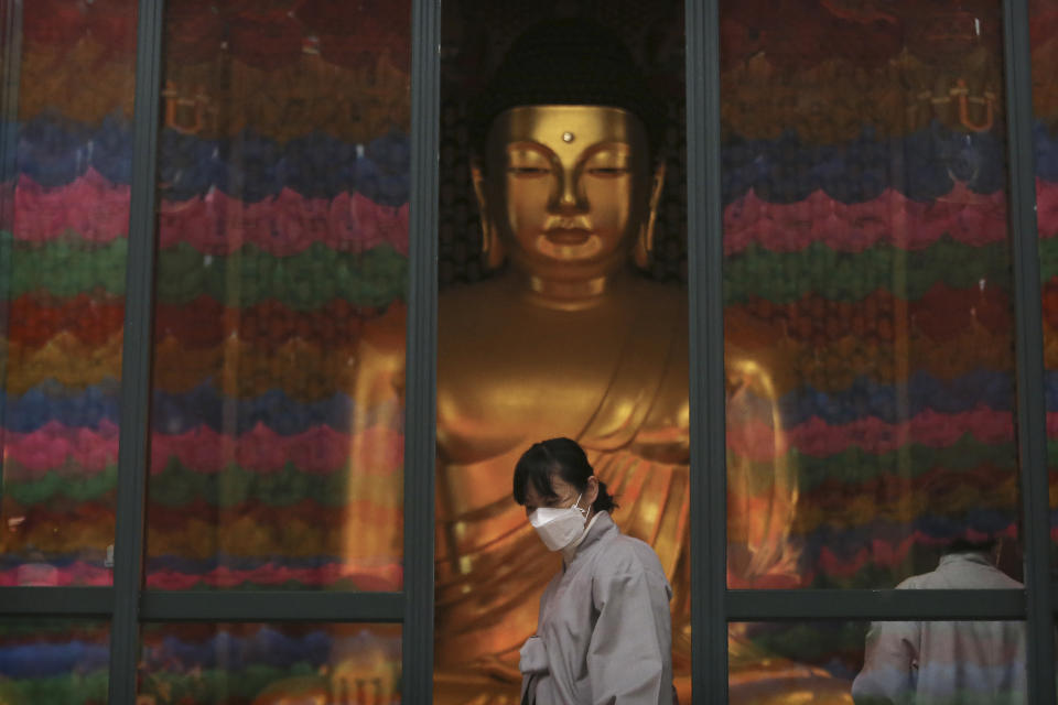 A Buddhist believer wearing a face mask leaves the Jogyesa Buddhist temple in Seoul, South Korea, Tuesday, Feb. 25, 2020. South Korea reported another large jump in new virus cases Monday a day after President Moon Jae-in called for "unprecedented, powerful" steps to combat the outbreak that is increasingly confounding attempts to stop the spread.(AP Photo/Ahn Young-joon)