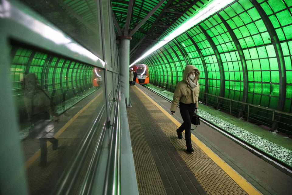 A woman wearing a face mask to protect against coronavirus walks at a train station in Moscow, Russia, Monday, Jan. 11, 2021. (AP Photo/Pavel Golovkin)