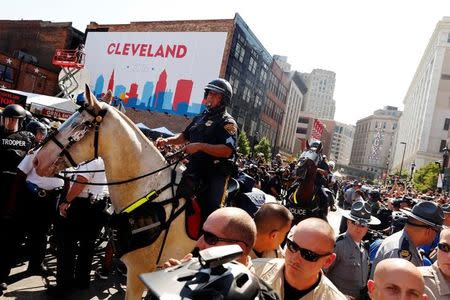 Cleveland police officers on horseback depart after clashes with a group attempting to burn a U.S. flag while protesting near the Republican National Convention in Cleveland, Ohio, U.S., July 20, 2016. REUTERS/Lucas Jackson